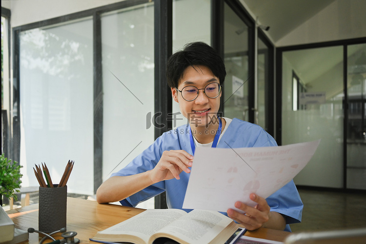微笑的男医学生阅读书籍，准备在