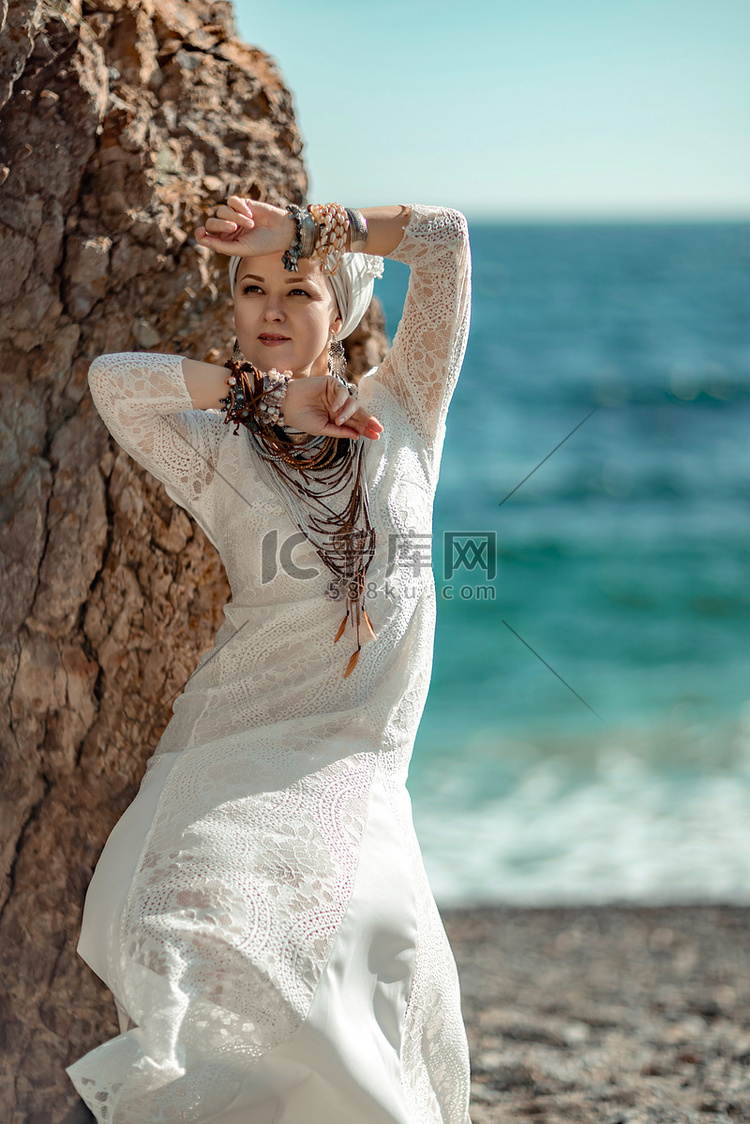 女人白色连衣裙海石岩石。中年女