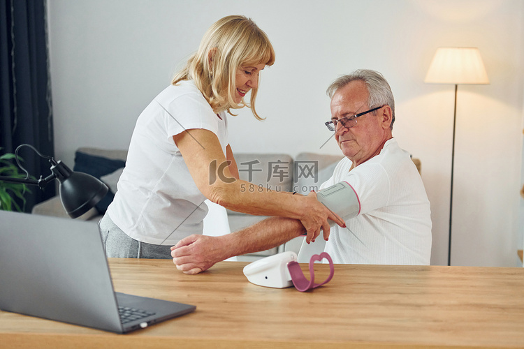 妻子测量丈夫的血压。