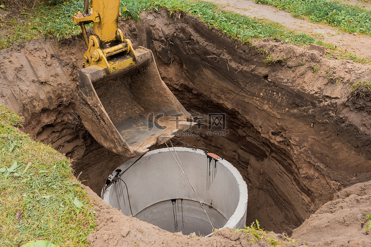 带桶的挖掘机，降低到钢缆混凝土