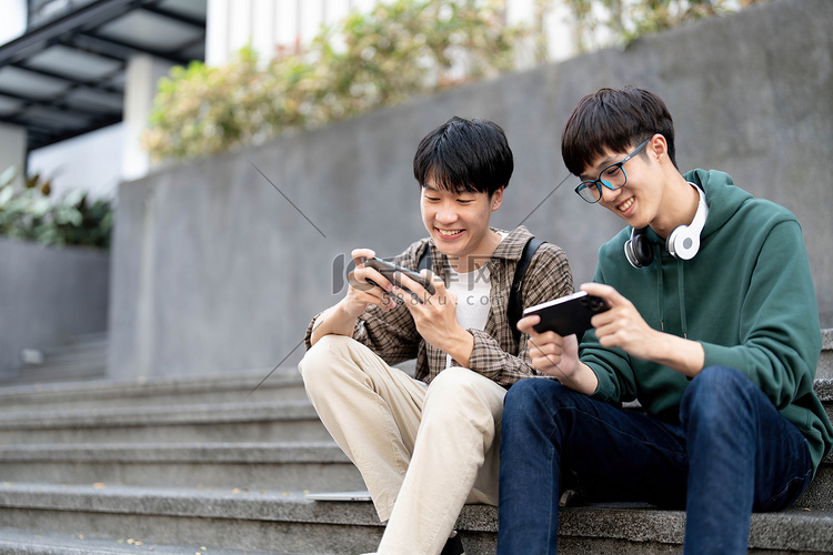快乐的亚洲男大学生和朋友在智能