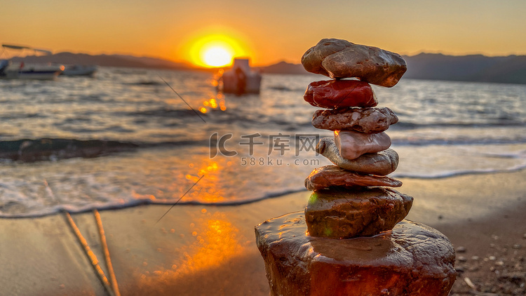 日落时在海滩上的岩石平衡近景