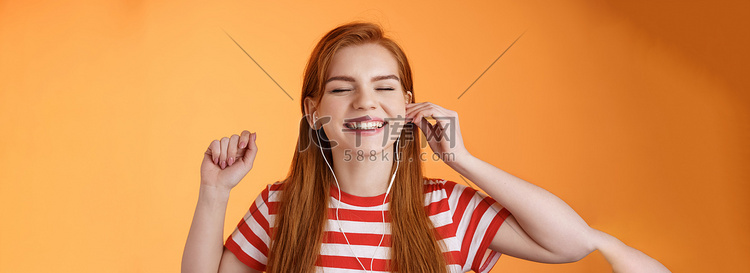 无忧无虑的快乐红发女人戴上耳机