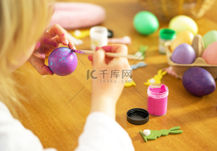 让孩子手在木桌上画复活节彩蛋。