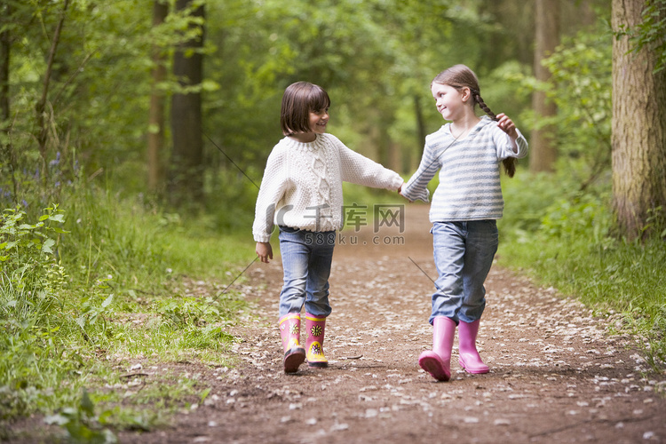两姐妹牵着手微笑走在路上