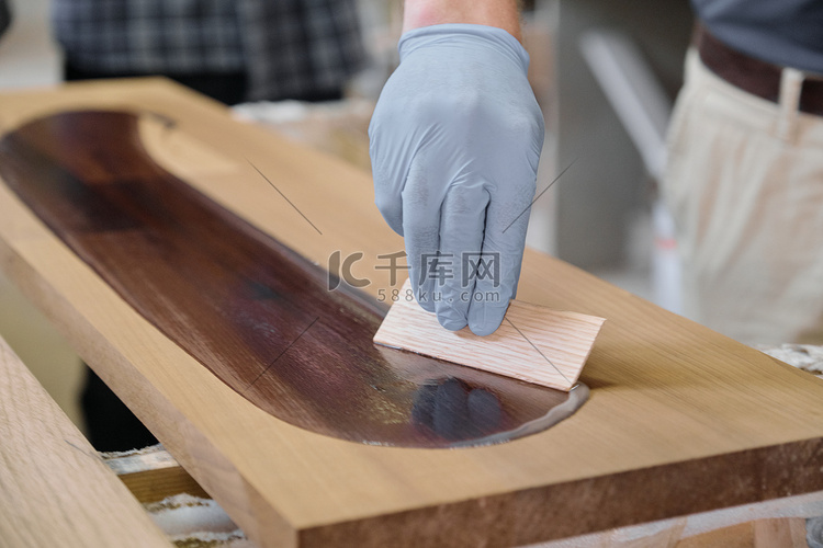 工人用手覆盖木板的特写，带有木