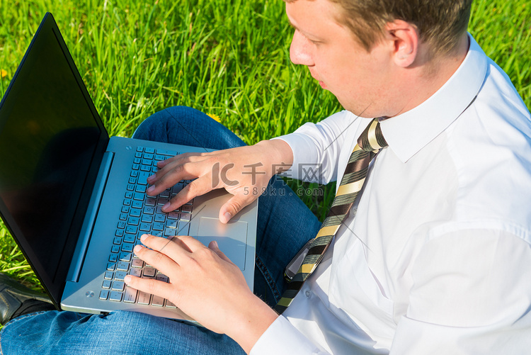 上班族在草坪上用笔记本电脑工作