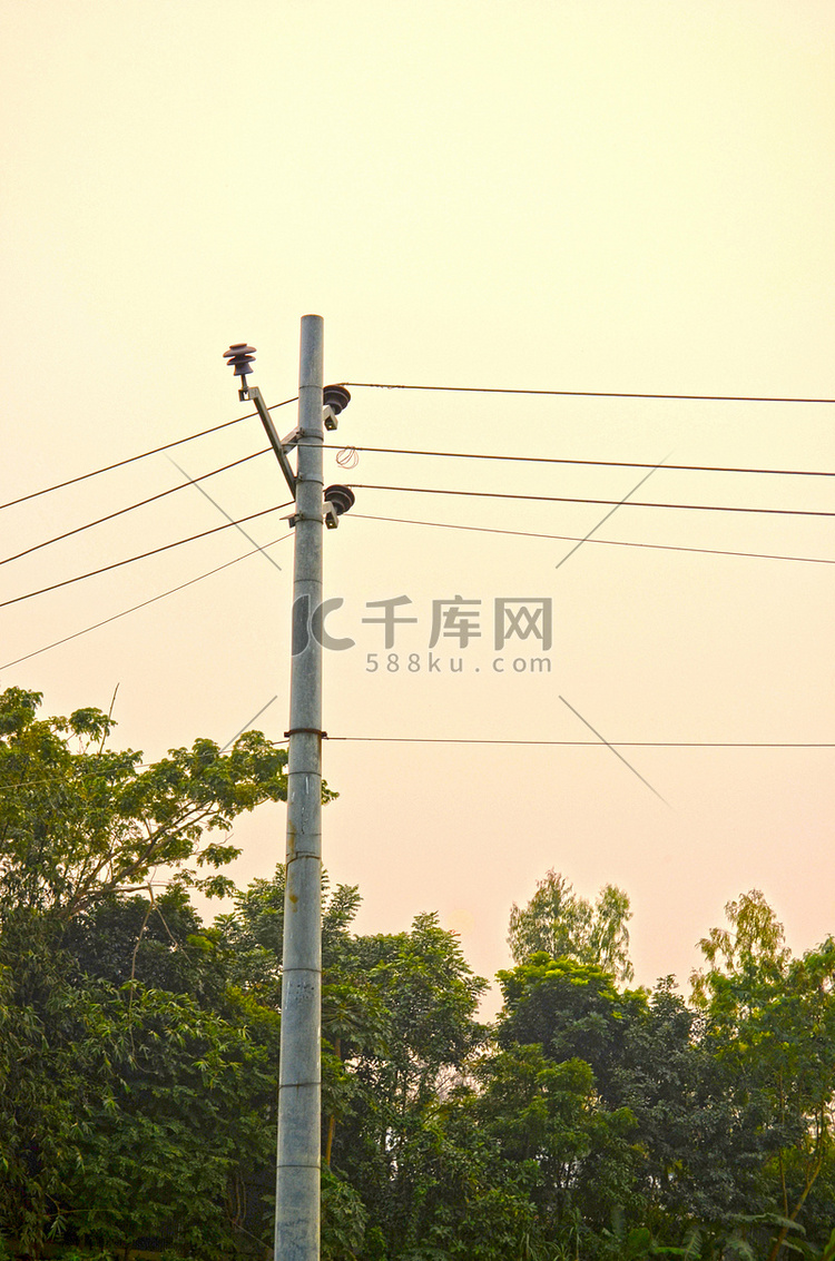 日落天空背景上的高压柱塔和输电