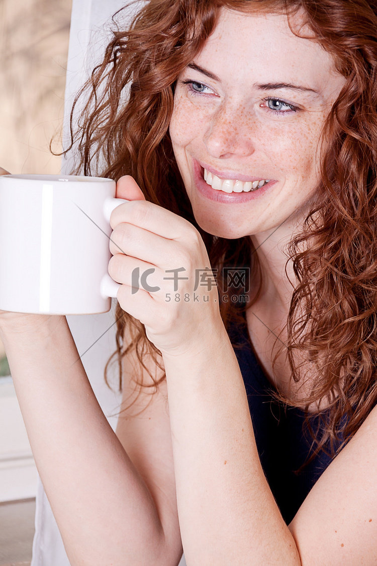 有雀斑和咖啡的漂亮年轻红发女人