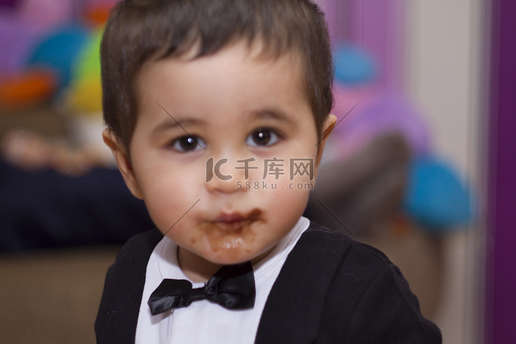 吃巧克力的可爱的愉快的婴孩，穿