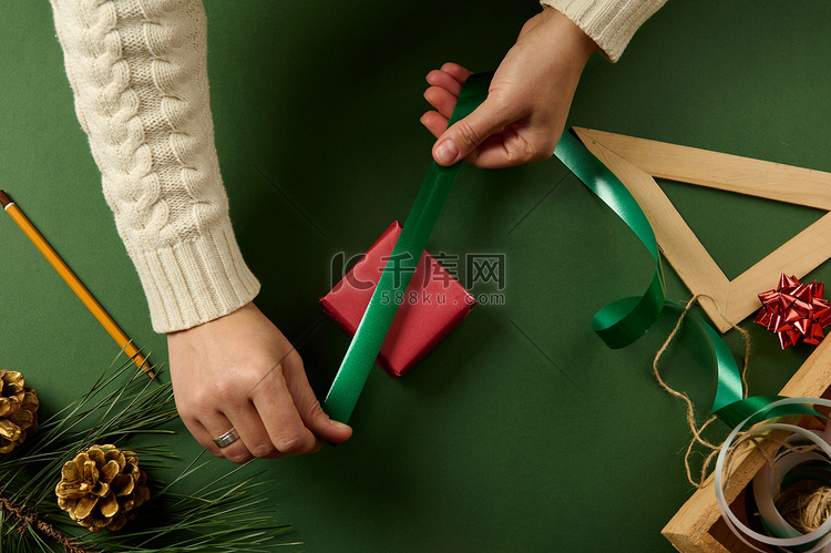 女人的手包裹着圣诞礼品盒，特写