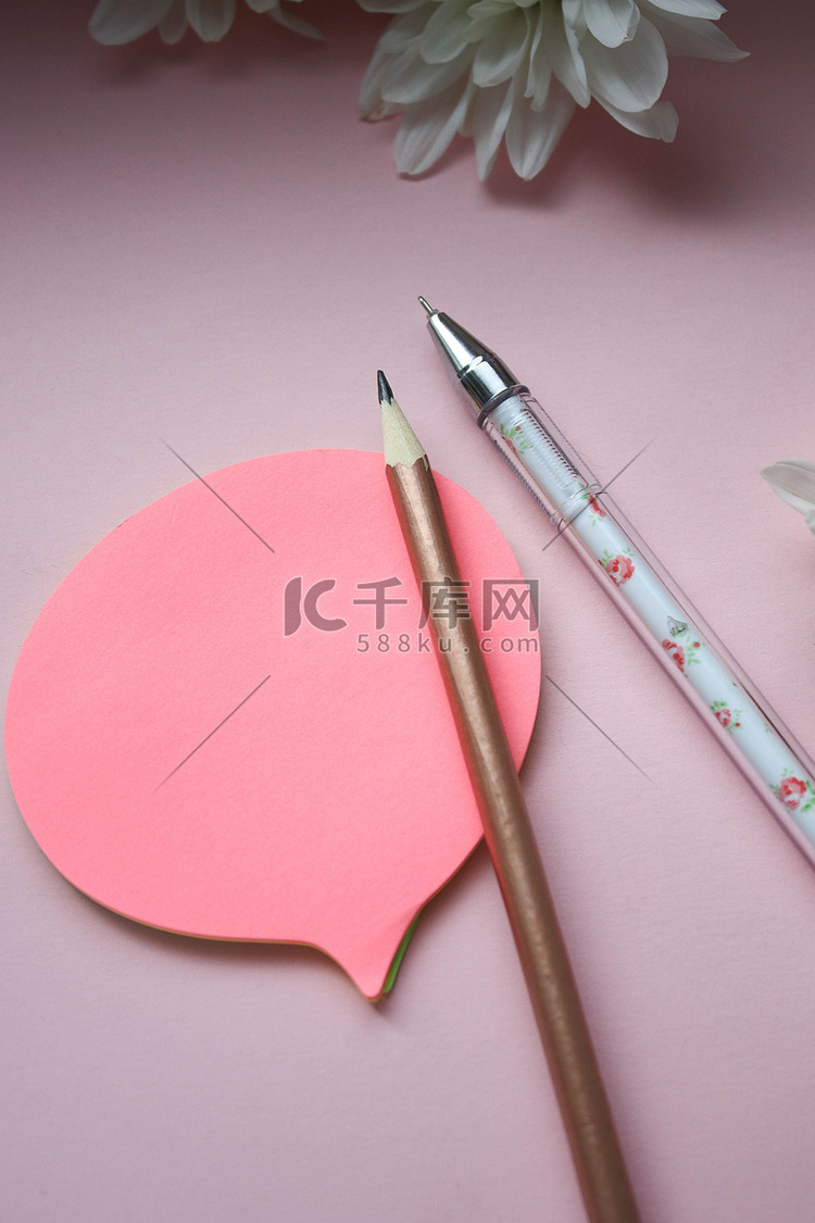 粉红色背景中带有钢笔、铅笔和鲜