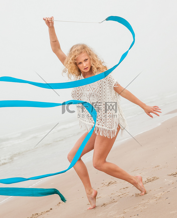 体操女子在沙滩上用丝带跳舞