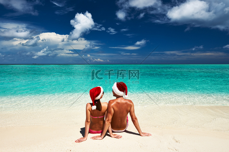 马尔代夫海滩上戴着圣诞帽的情侣