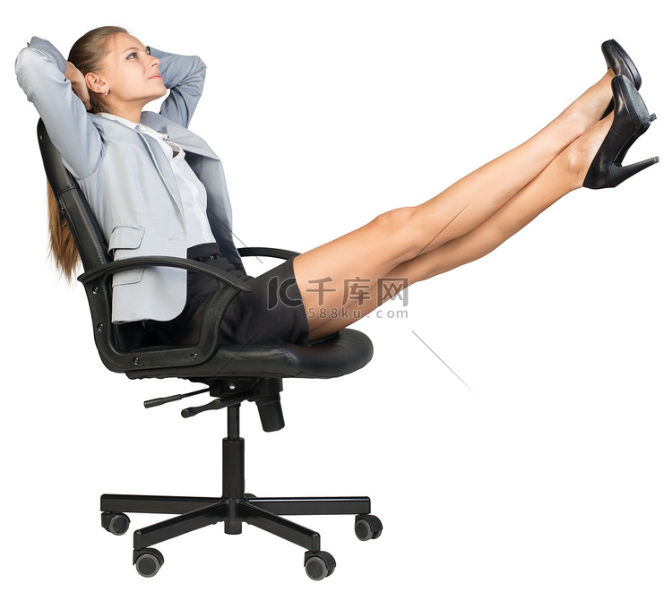 女商人坐在办公椅上，双脚抬起