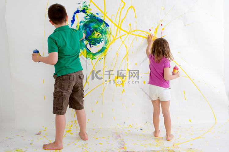 两个小孩徒手画在墙上