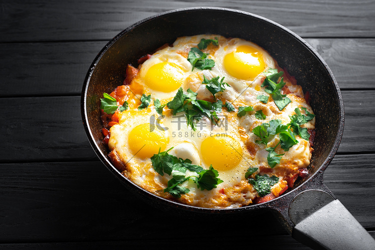 深色桌面上的一盘煎鸡蛋和西红柿