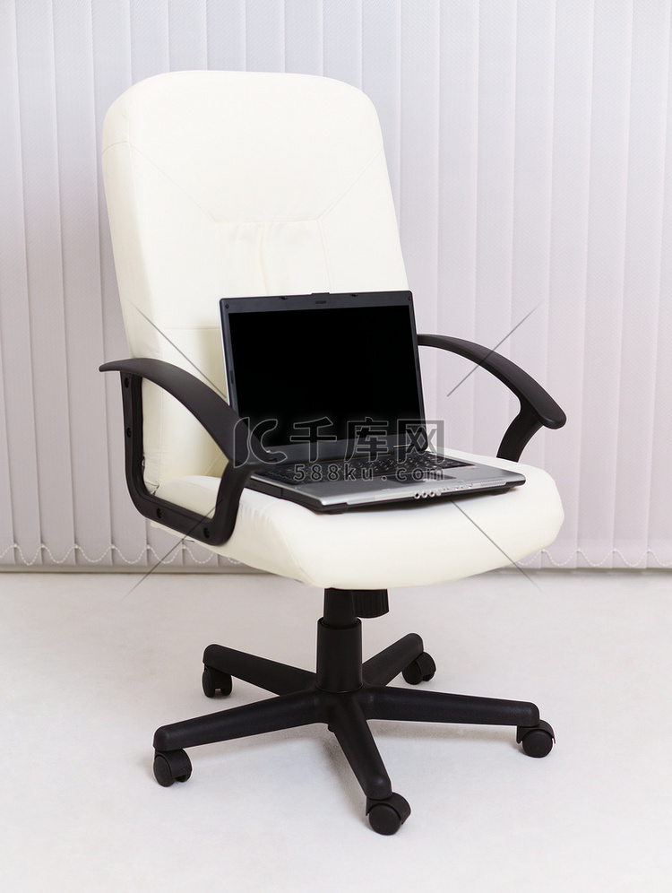 黑色笔记本电脑坐在经理的皮椅上