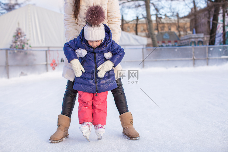 可爱的小女孩和她妈妈学滑冰