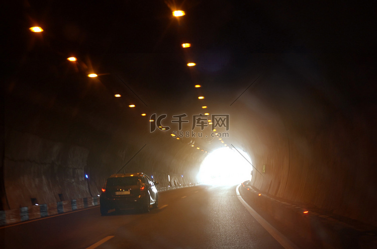 一辆汽车正驶向隧道出口。