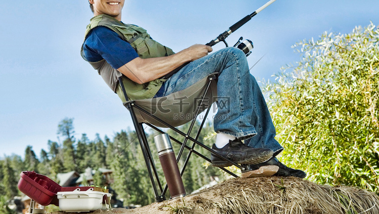在折叠椅上钓鱼的人