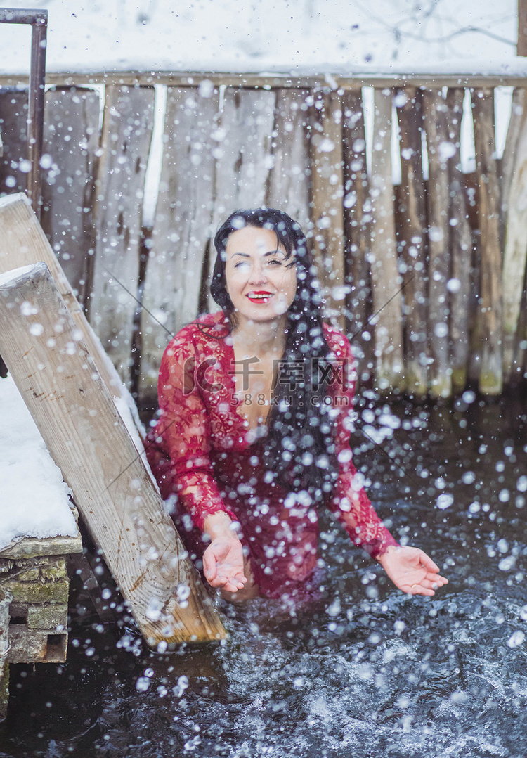 冬天，穿红裙子的美女在冰洞里沐