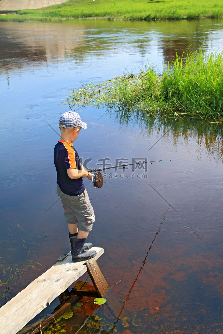 男孩在小河上钓鱼
