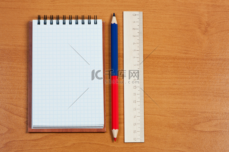 “木制背景上的笔记本、铅笔和尺