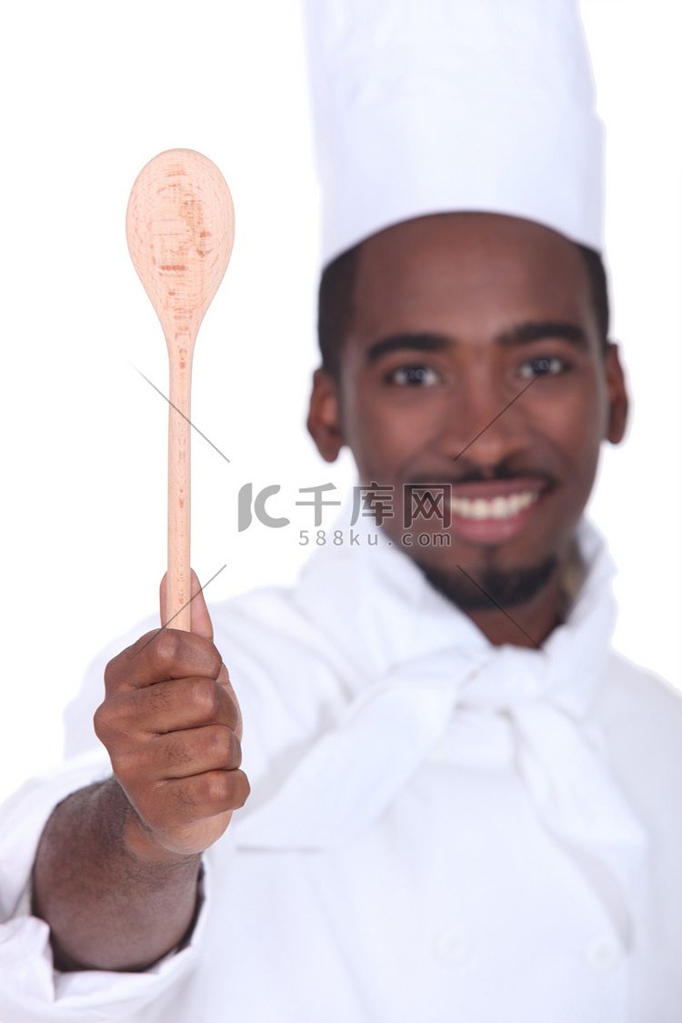 展示木勺的黑人厨师