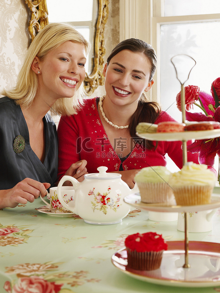 坐在餐桌旁的两个微笑的年轻女性