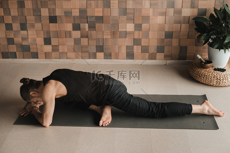 一个男人在家里的瑜伽垫上做体操