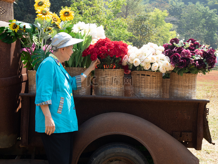 亚洲老年老年妇女在花园里拿着花