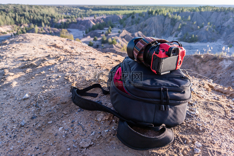 夏日山顶上的专业相机和摄影背包