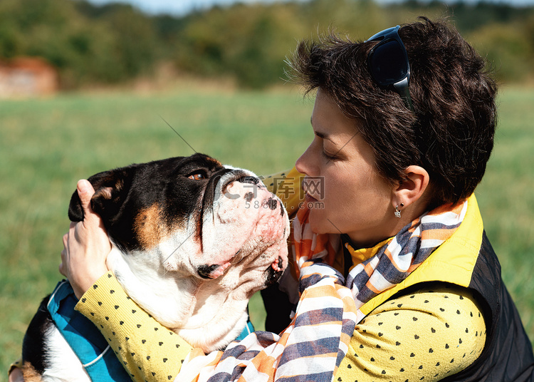 一个女人和一只英国斗牛犬在温暖