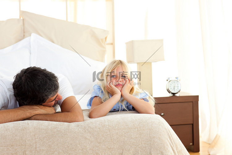 悲伤的小女孩和父亲躺在床上