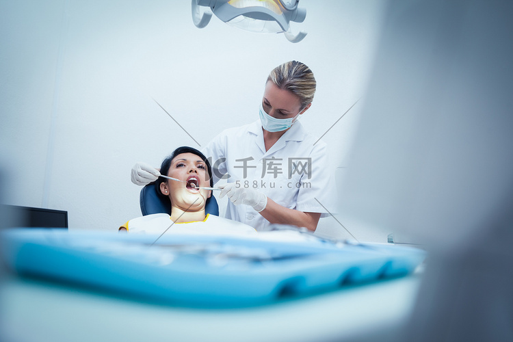 女牙医检查女人的牙齿