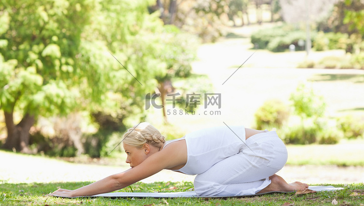 一个女人在公园里做伸展运动的侧