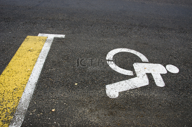 在柏油路街道背景的轮椅障碍标志