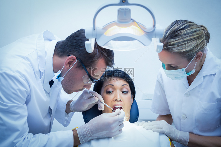 牙医助理检查女人的牙齿