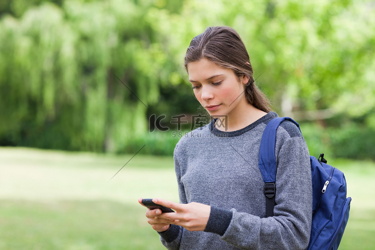 年轻冷静的女孩用手机发短信
