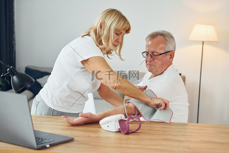 妻子测量丈夫的血压。