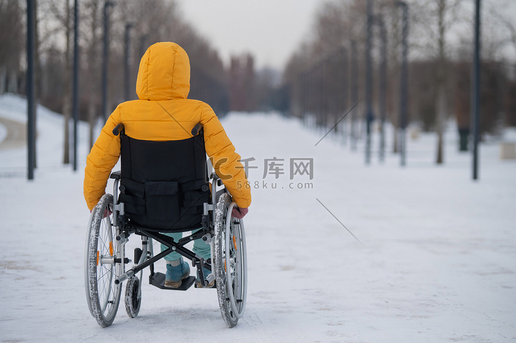 冬天，白人残疾妇女坐在公园的椅