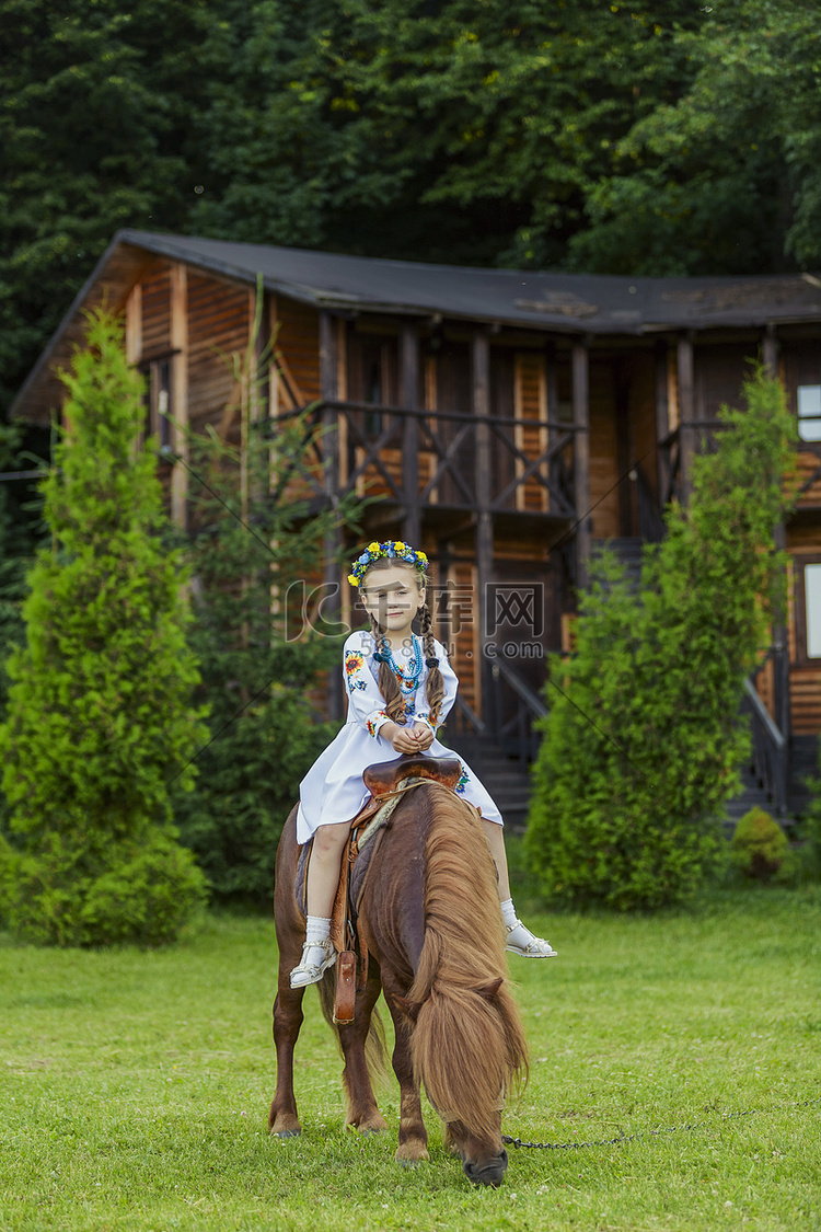 乌克兰民族服装的小女孩骑着小马