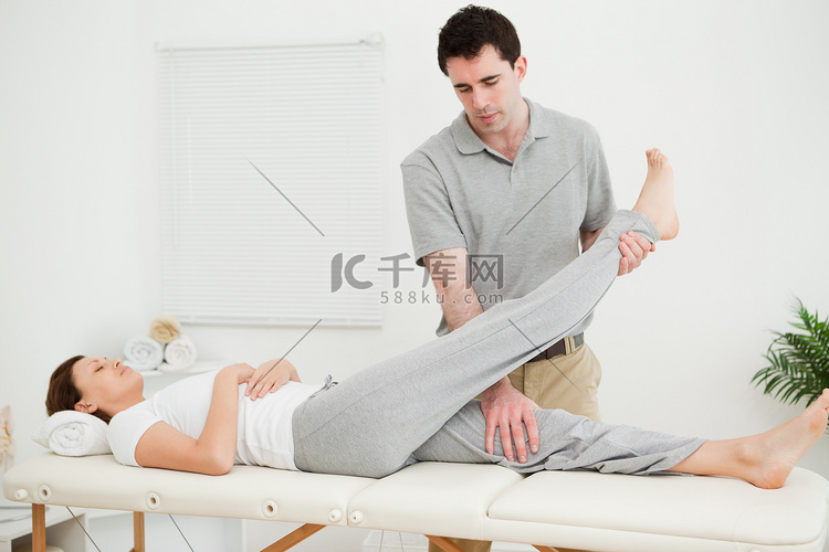布鲁内特物理治疗师抬高病人的腿