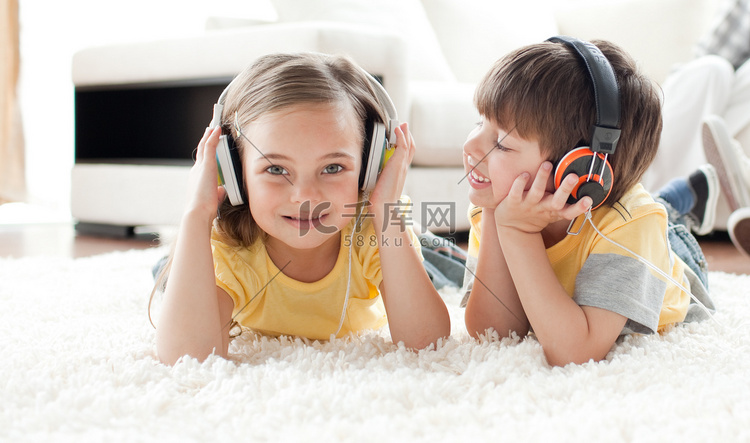 孩子们戴着耳机在地板上玩耍