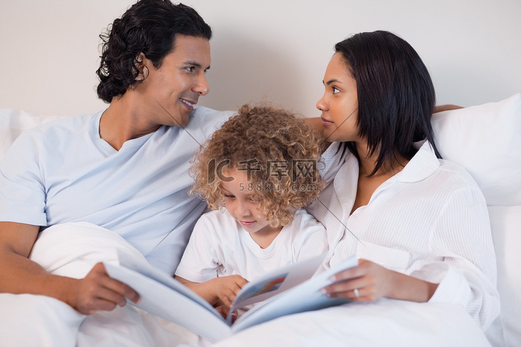 一家人坐在床上看书