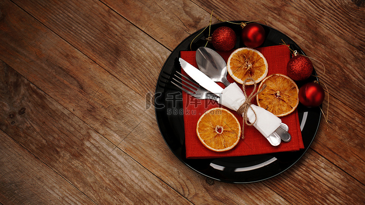 圣诞晚餐装饰，黑盘上放着干橙子