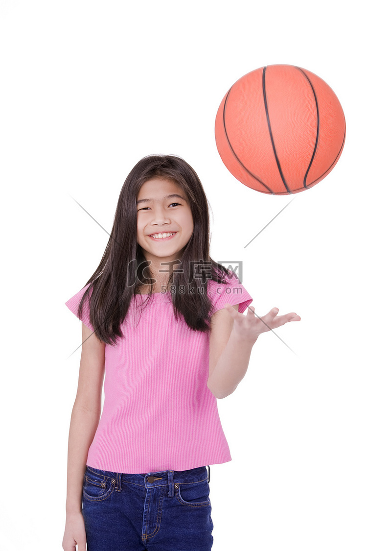 “投掷篮球的年轻女孩，被白色隔