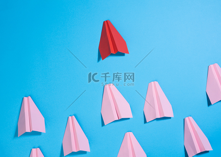 一组粉红色的纸飞机跟随蓝色背景