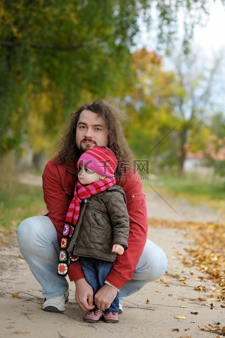父亲和他的孩子在秋天的公园里